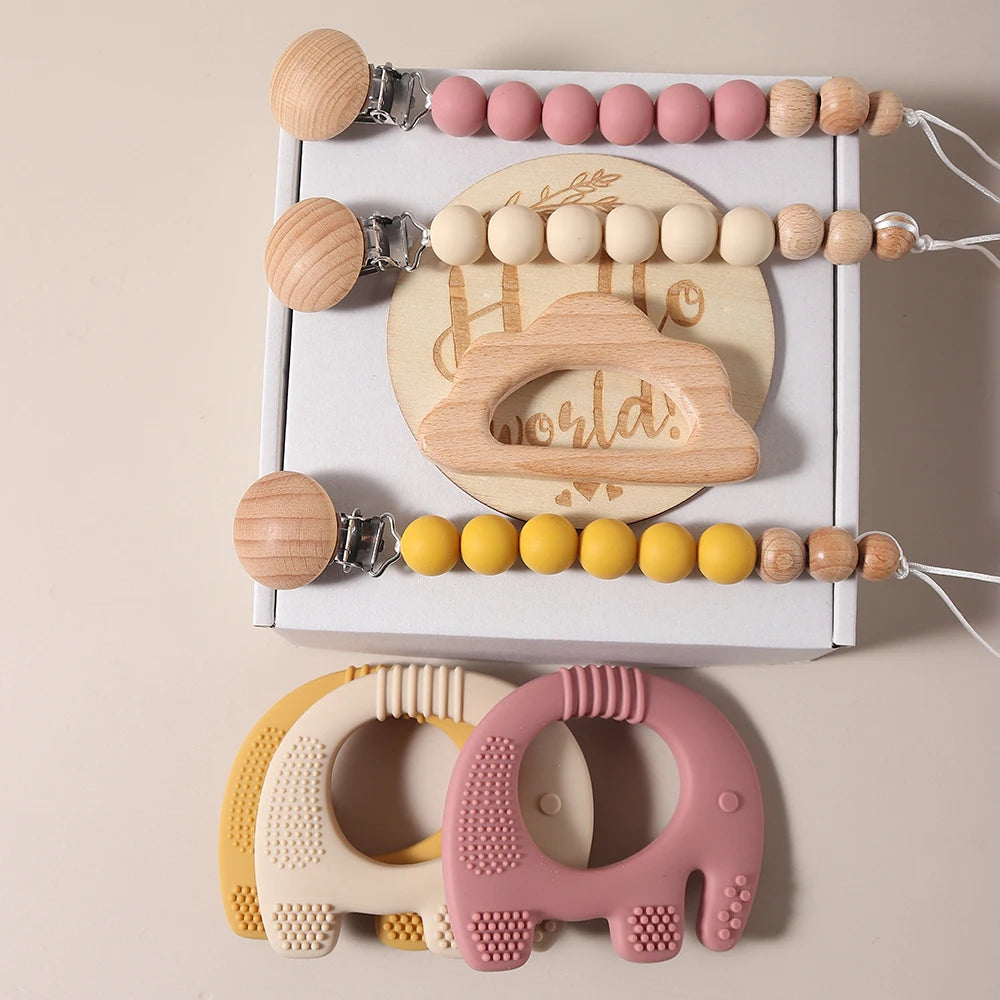 Baby teething toy set with wooden and silicone elements on a beige background
