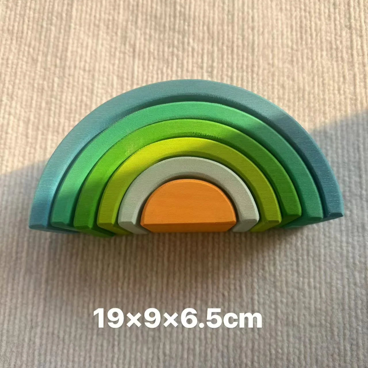 Wooden rainbow toy with dimensions 19x9x6.5cm on a beige background