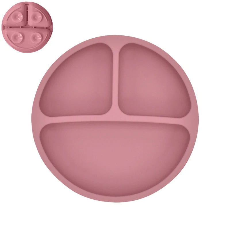 Pink silicone plate with divided sections on a white background