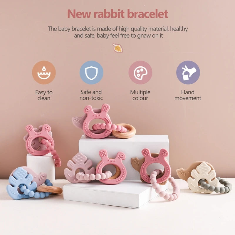 Baby bracelet with rabbit design on a white surface against a beige background