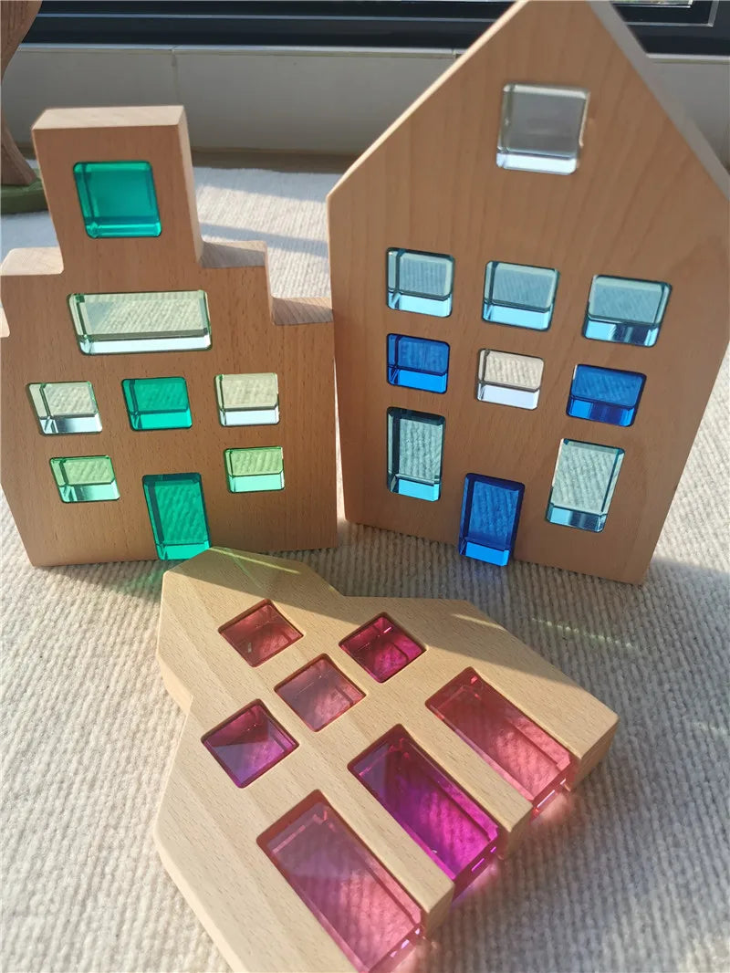 Wooden house models with colorful transparent windows on a textured surface.