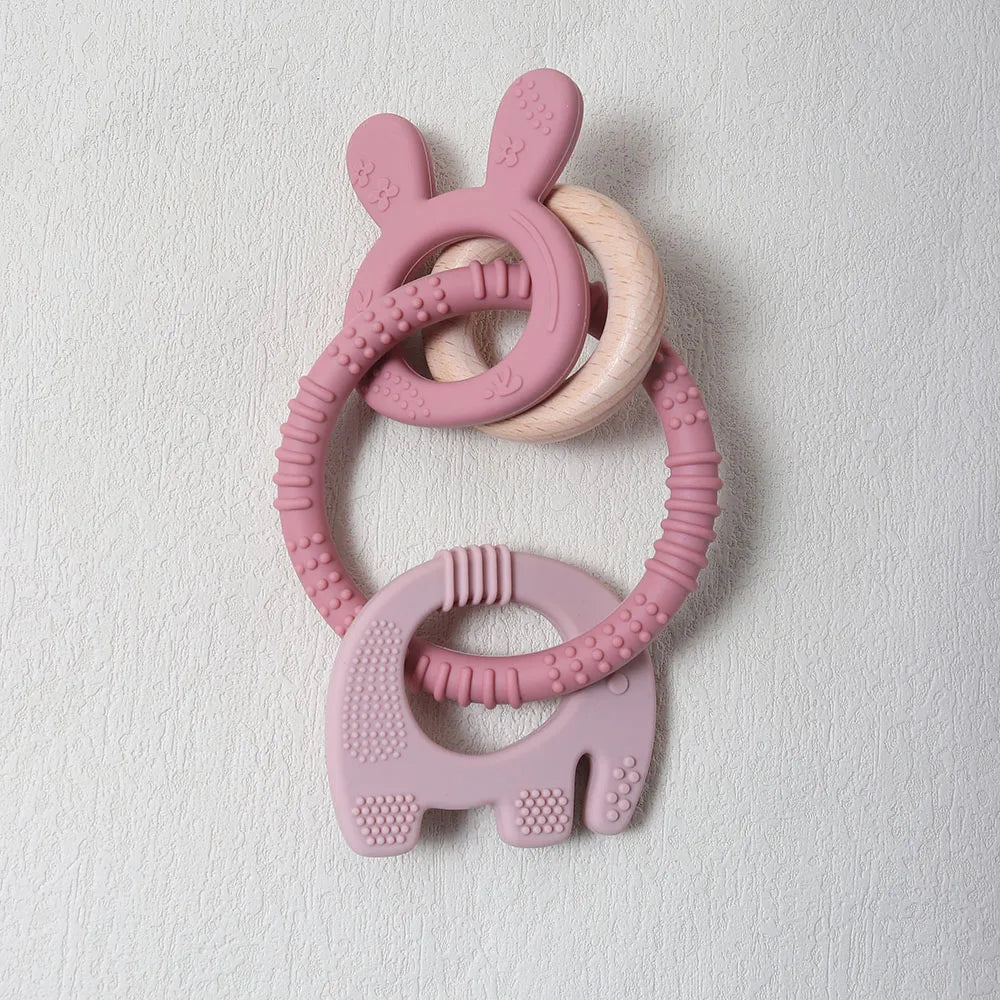 Pink silicone teething ring with bunny design on a light gray background