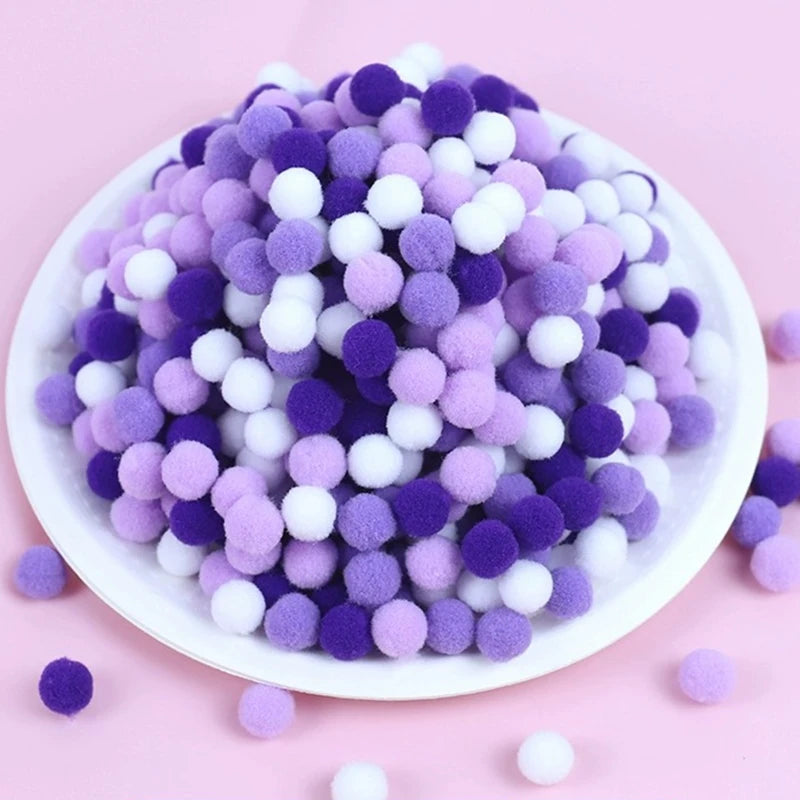 White plate with purple, white, and lavender pom-poms on a pink background