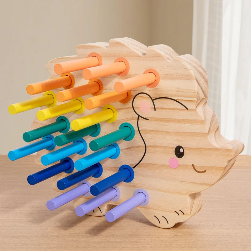 Wooden hedgehog toy with colorful pipes on a wooden surface