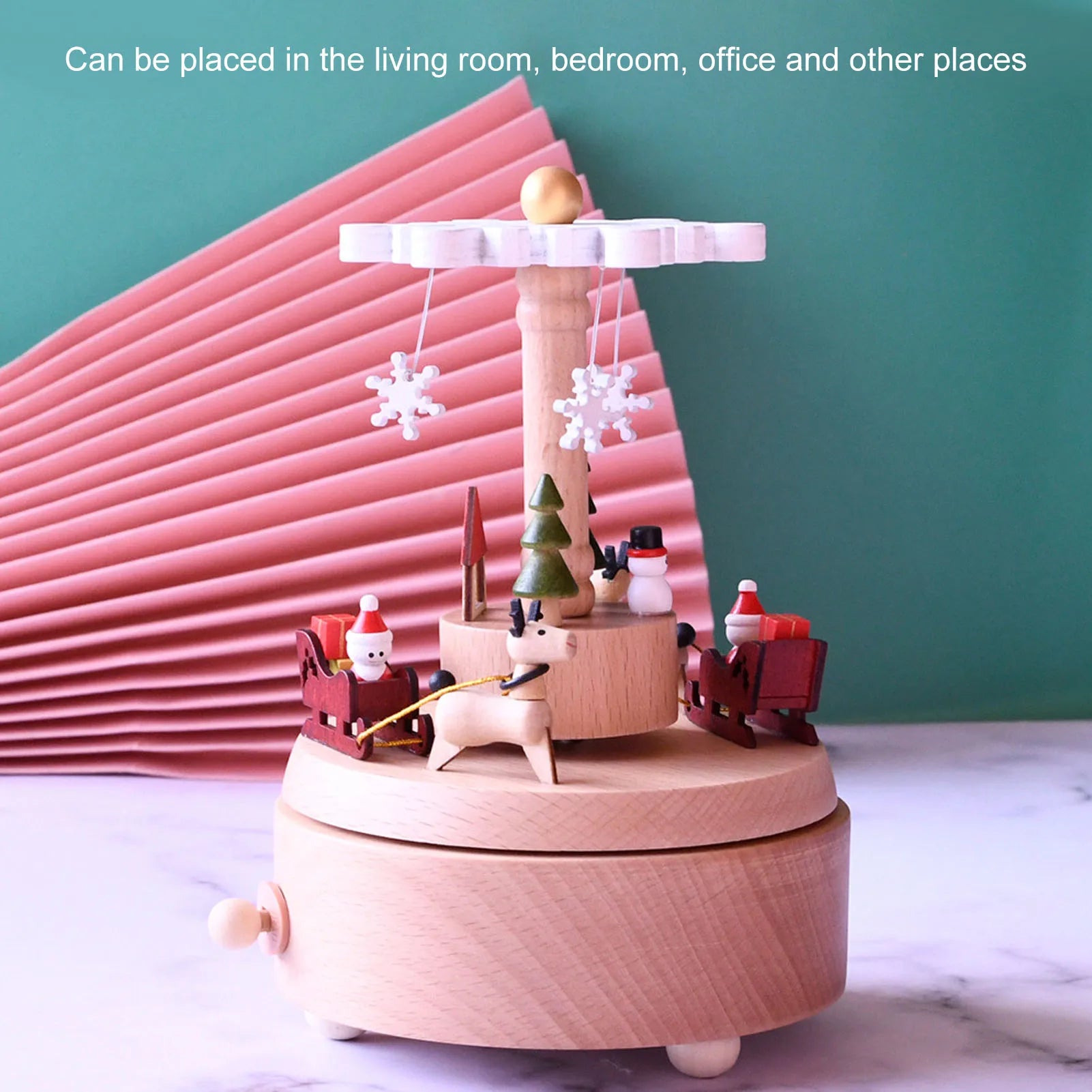 Wooden Christmas-themed music box with Santa Claus and snowflakes on a light surface.