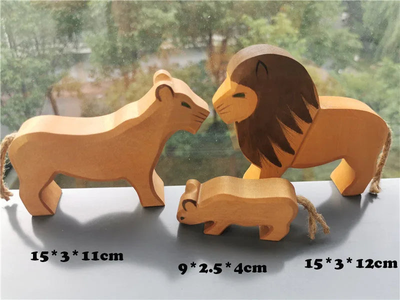 Three wooden lion figurines of different sizes on a reflective surface with a blurred natural background.