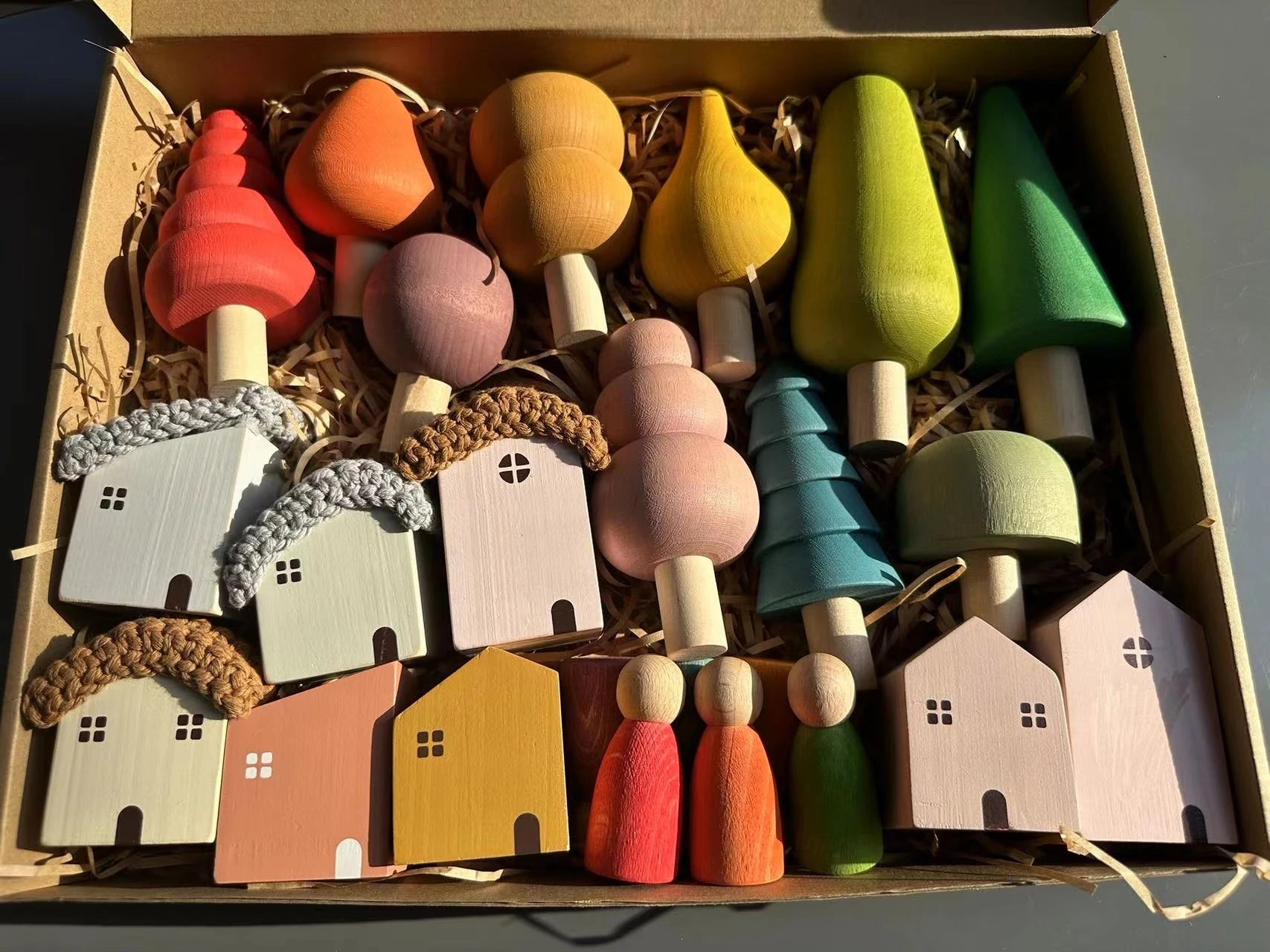 Colorful wooden houses and trees in a box