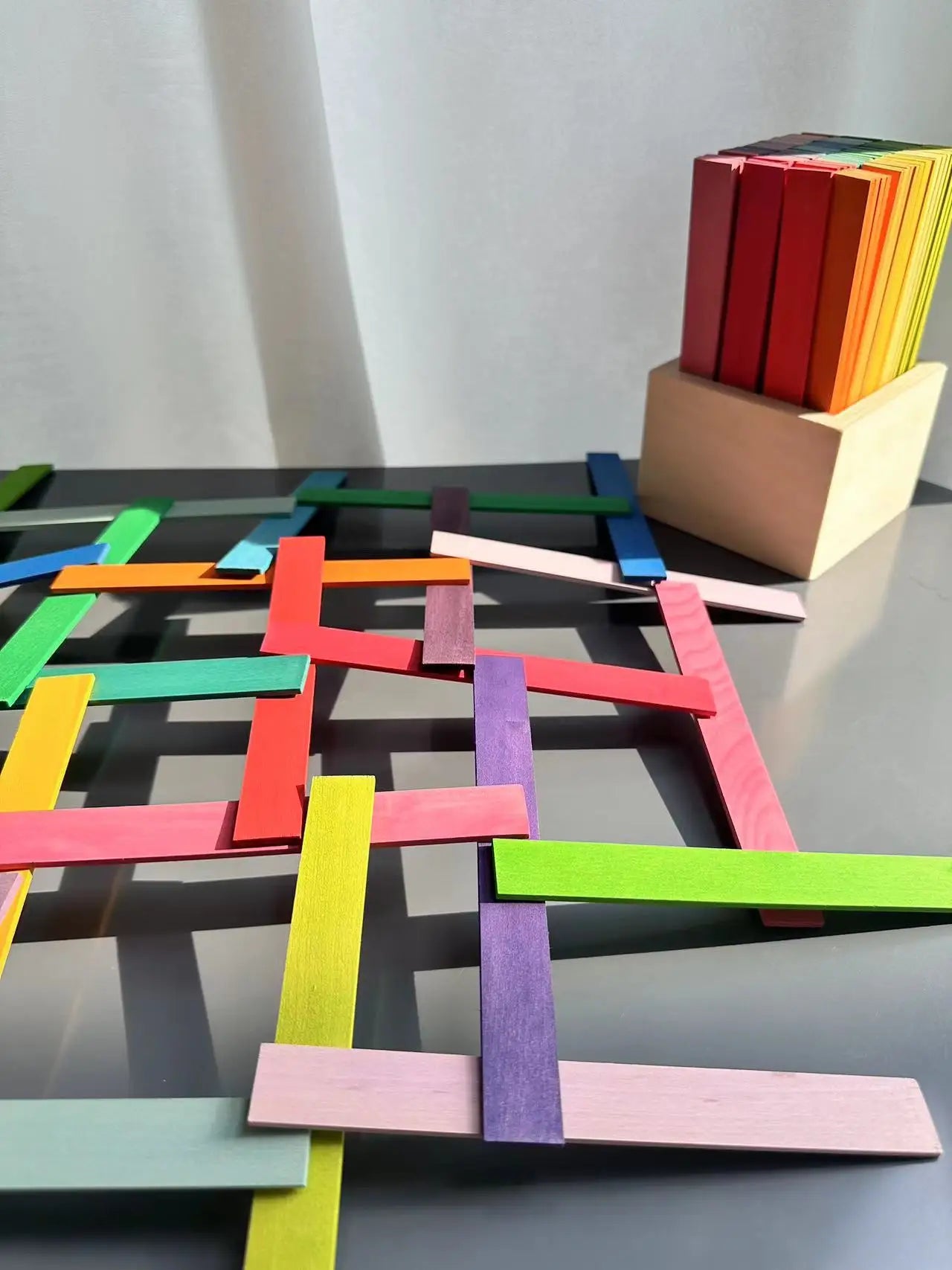 Colorful wooden blocks arranged in a geometric pattern on a reflective surface.