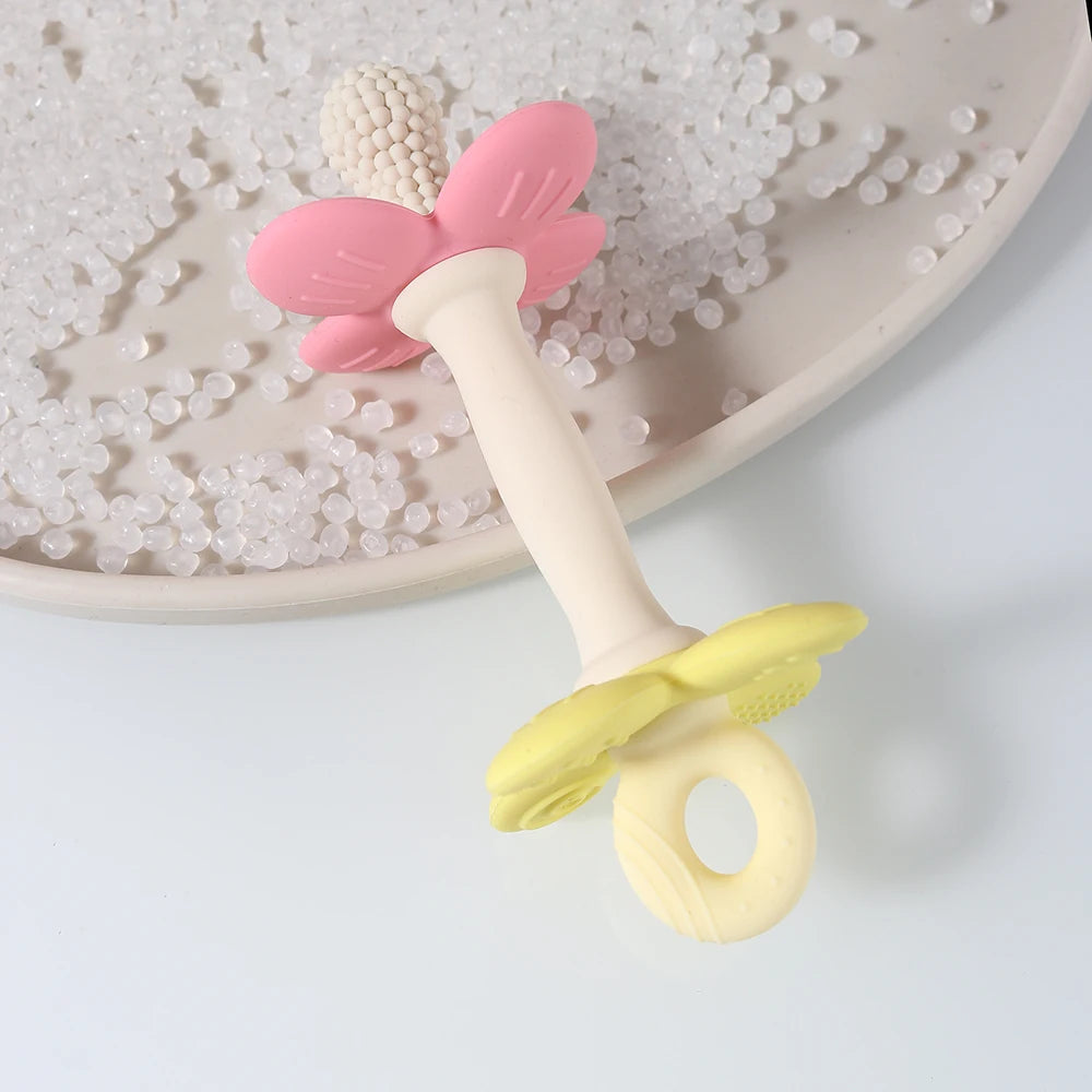 Butterfly-shaped baby teether with pink wings and yellow body on a white background