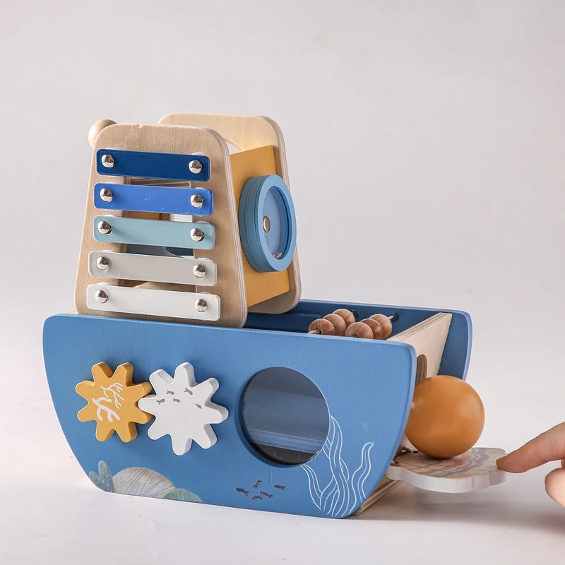 Wooden toy boat with xylophone and ball on a white background