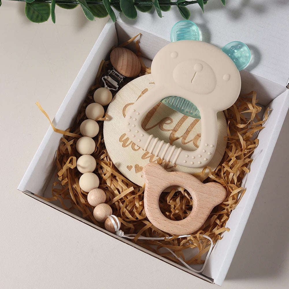 Baby teething ring with wooden elements and beads in a decorative box.