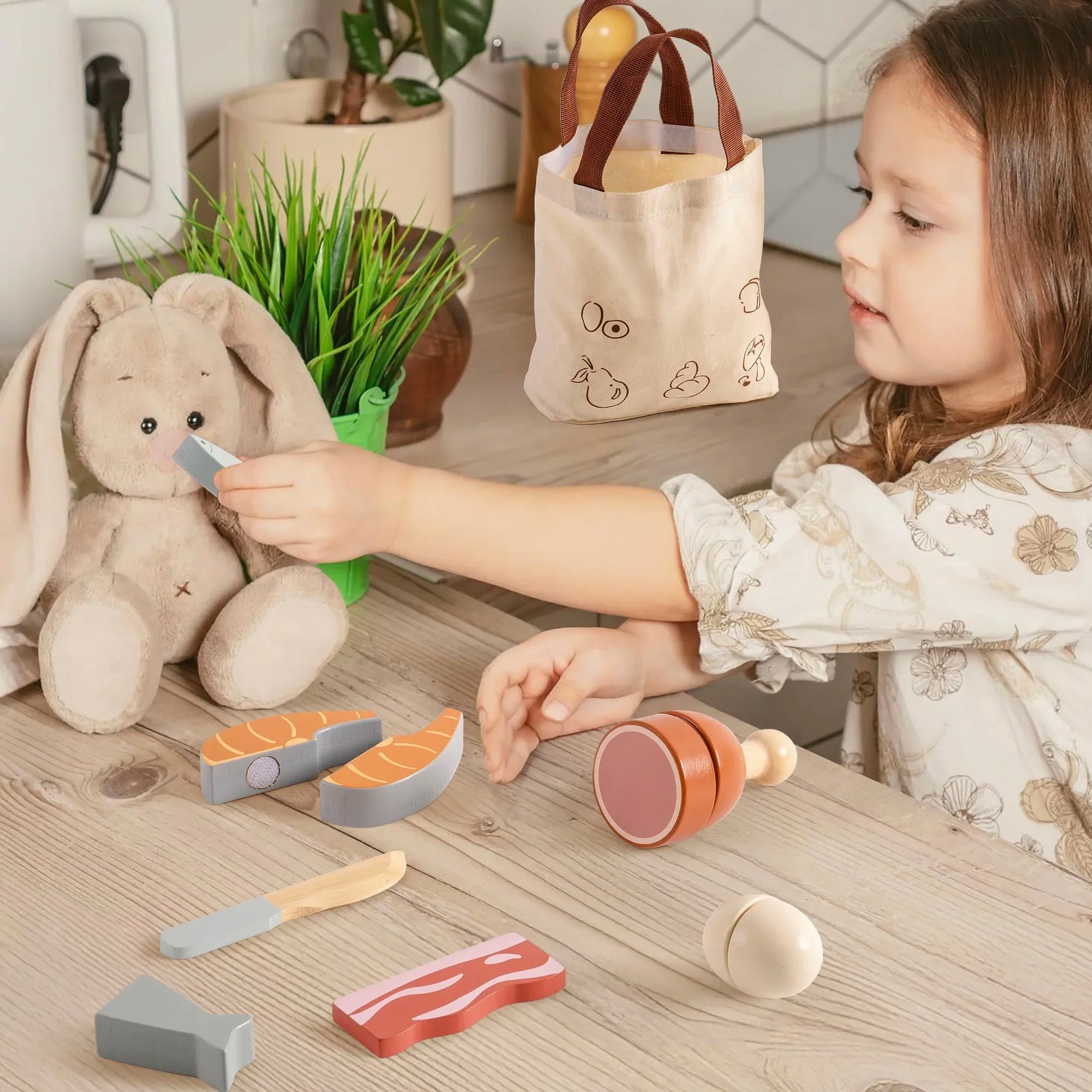 Child playing with toy food and a teddy bear on a wooden table.