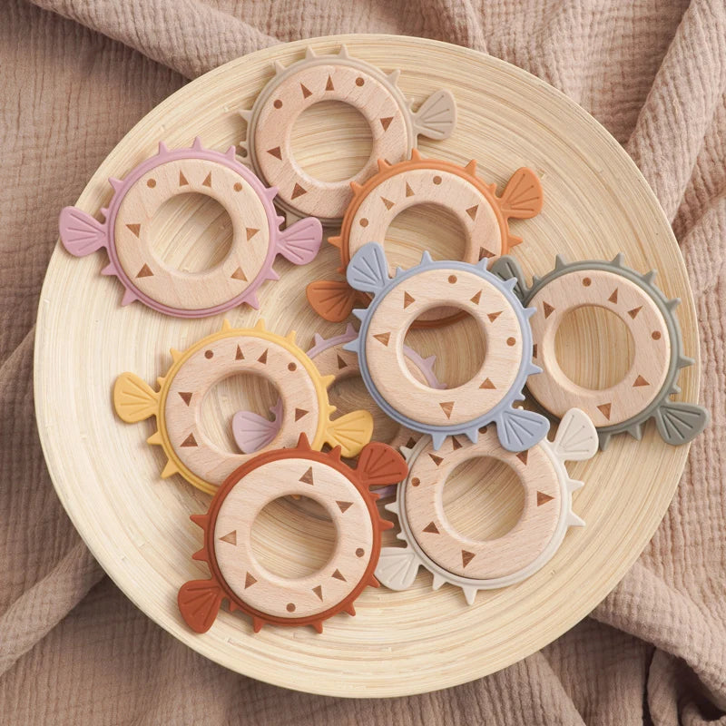 Pufferfish silicone teethers with wooden rings on a round tray