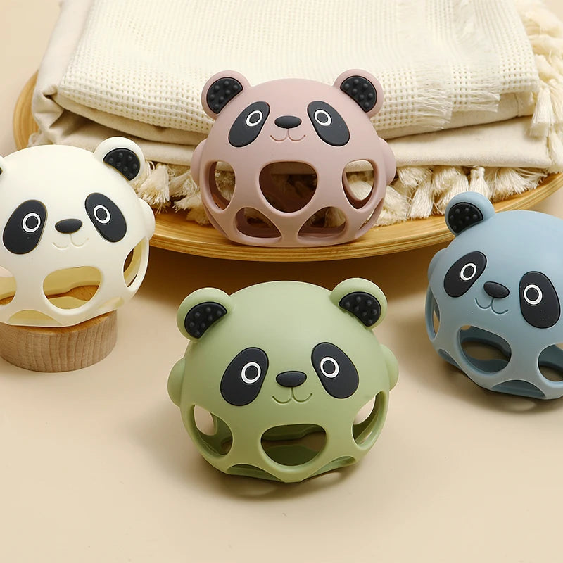 Four panda-shaped toys in different colors on a beige surface with a textured fabric background.
