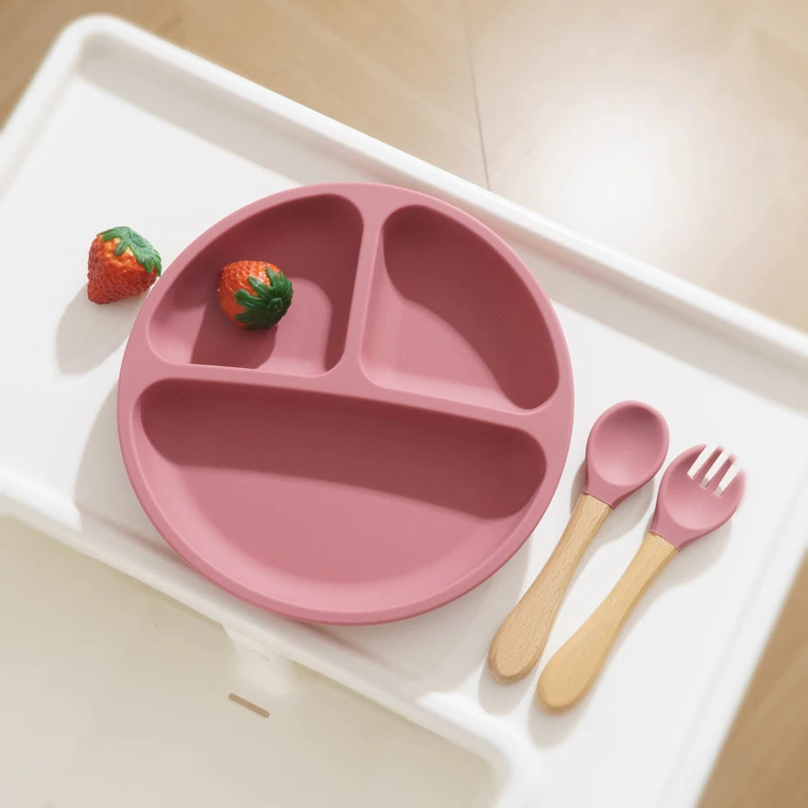 Mauve divided plate with wooden spoon and fork on a tray