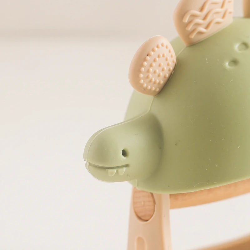 Close-up of a green and beige silicone teether on a light background