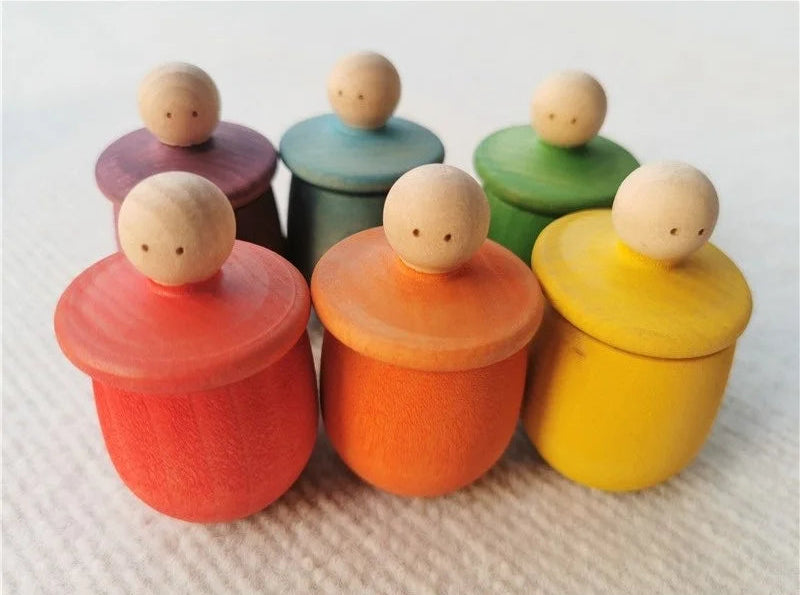 Set of colorful wooden containers with round lids on a textured surface