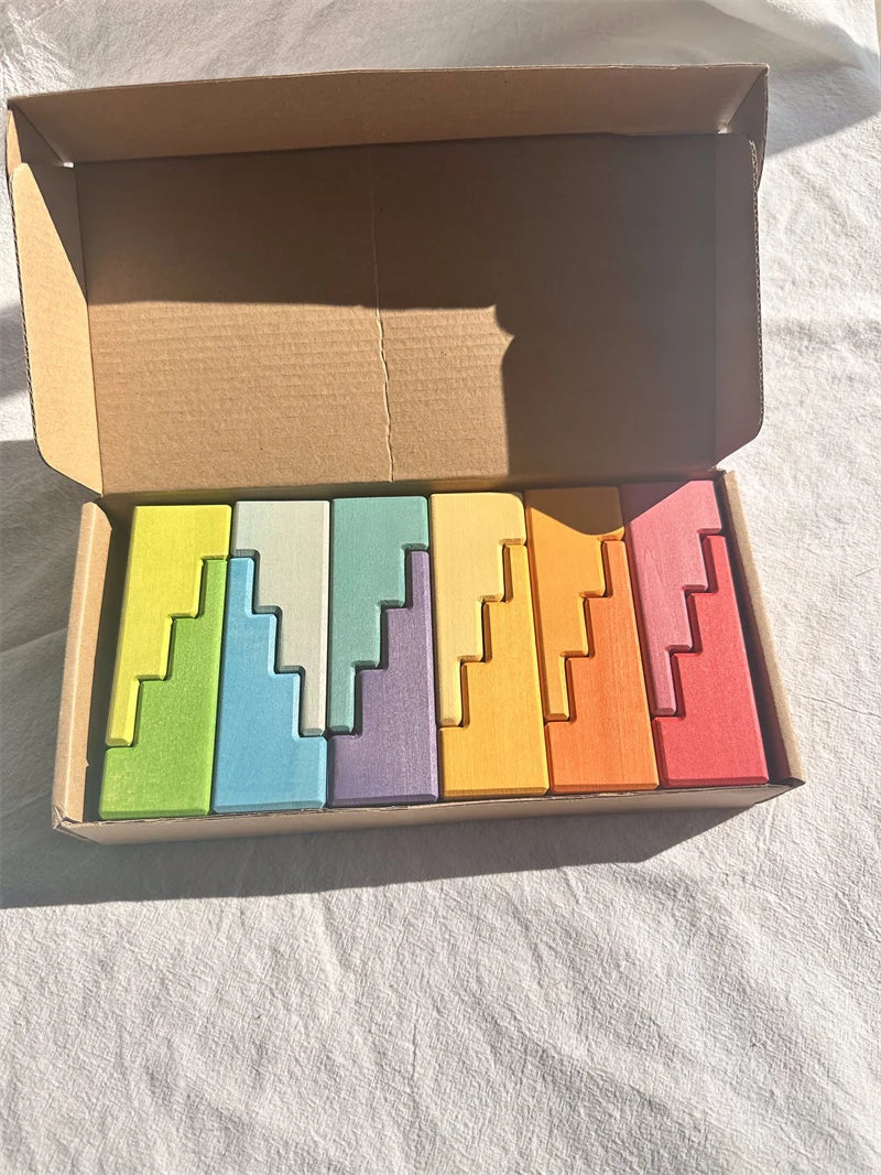 Set of colorful wooden blocks in a cardboard box on a white surface
