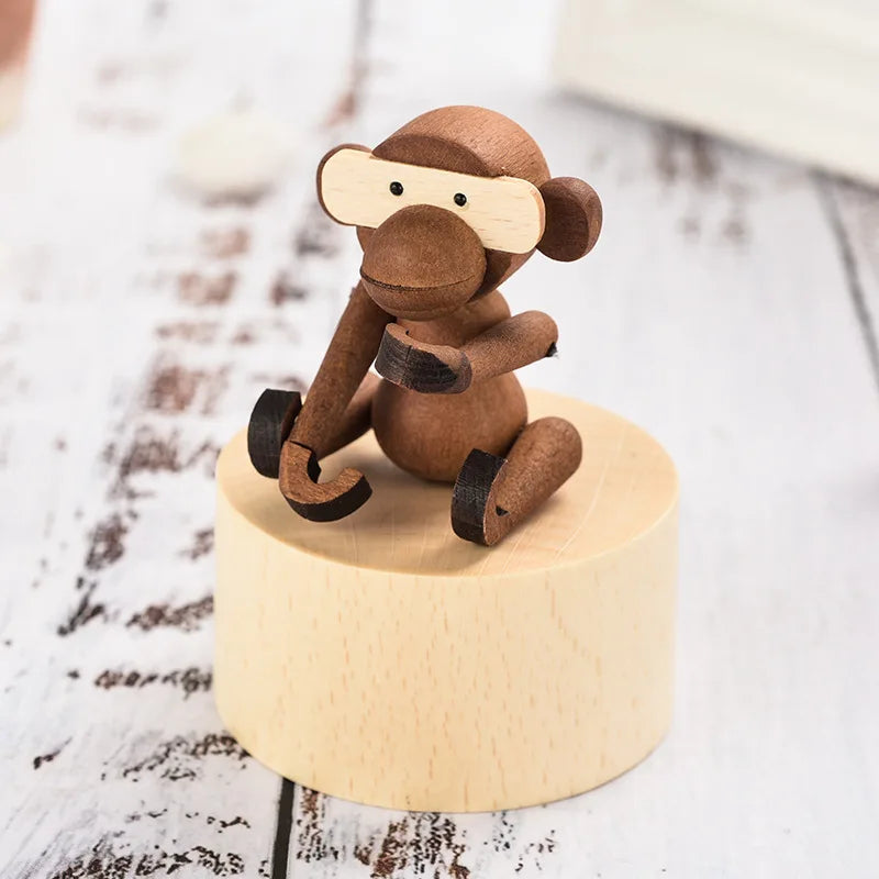 Wooden monkey figurine on a round wooden base with a white background | Oliver & Company Montessori toys