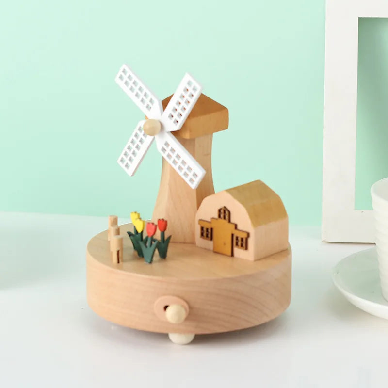Wooden windmill toy with a small house and figures on a light green background