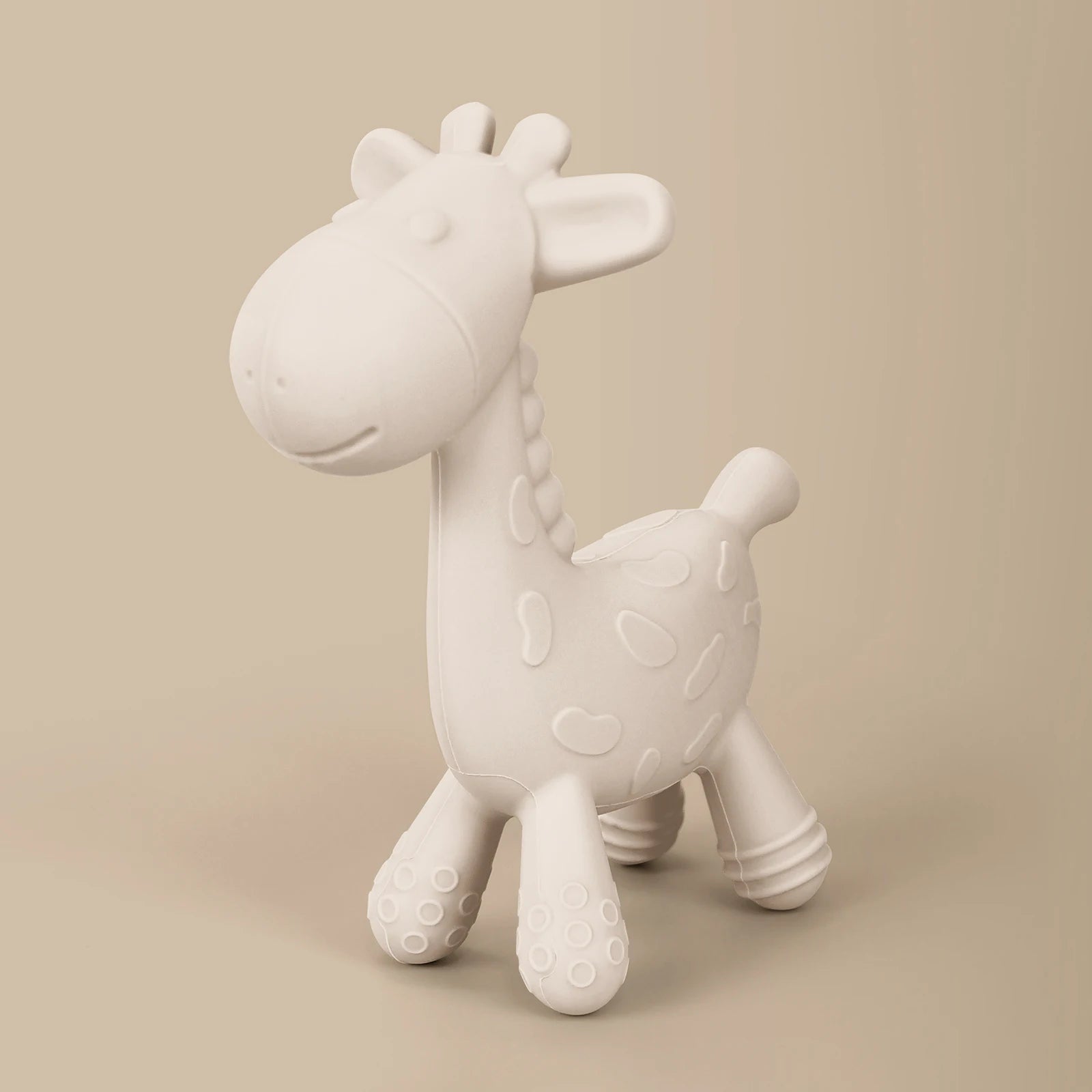White giraffe-shaped toy on a beige background