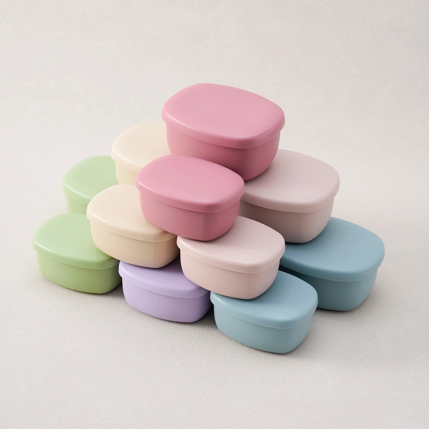 Stack of silicone food containers in rose, cream, sage, blue and lavender