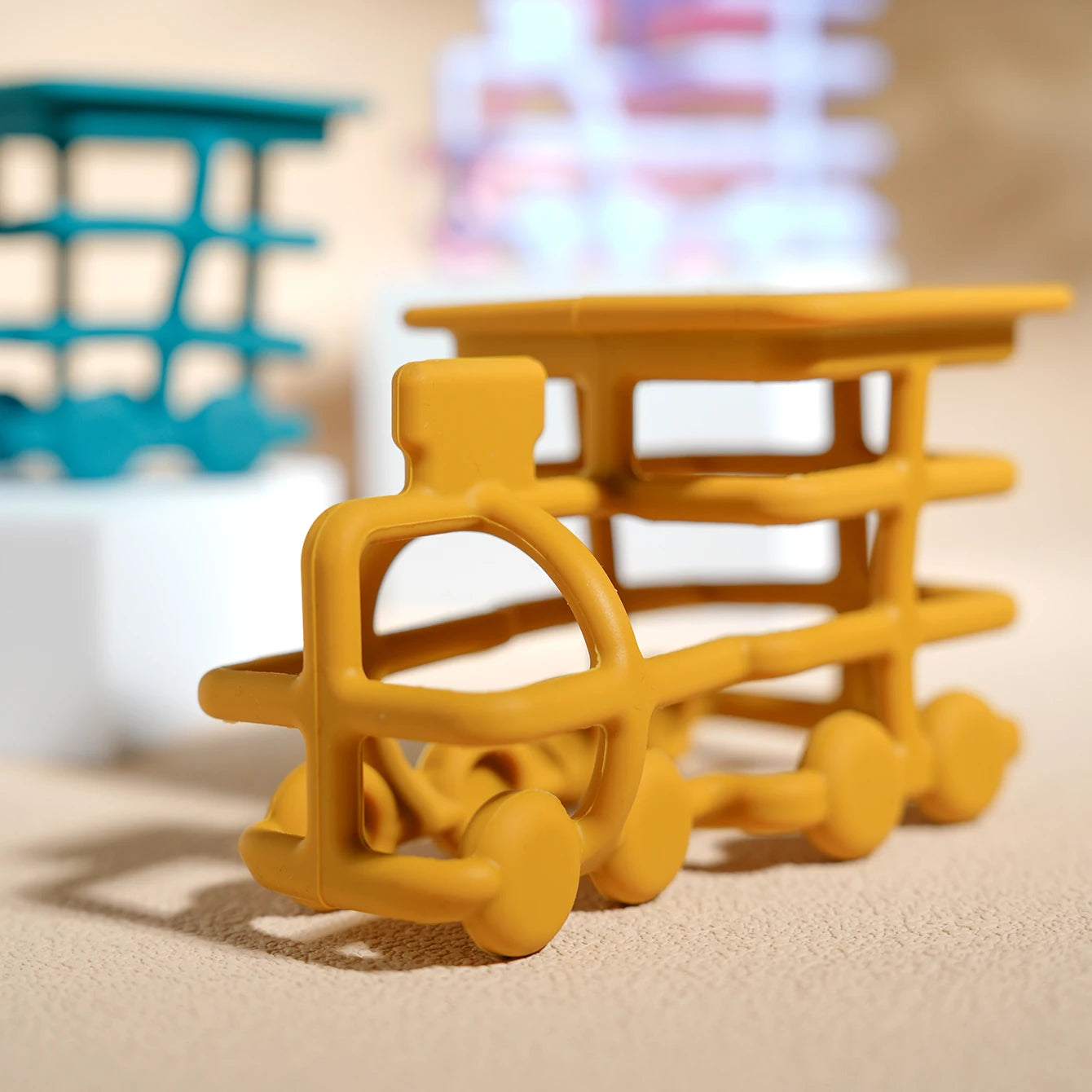 Close-up of a mustard silicone train teether