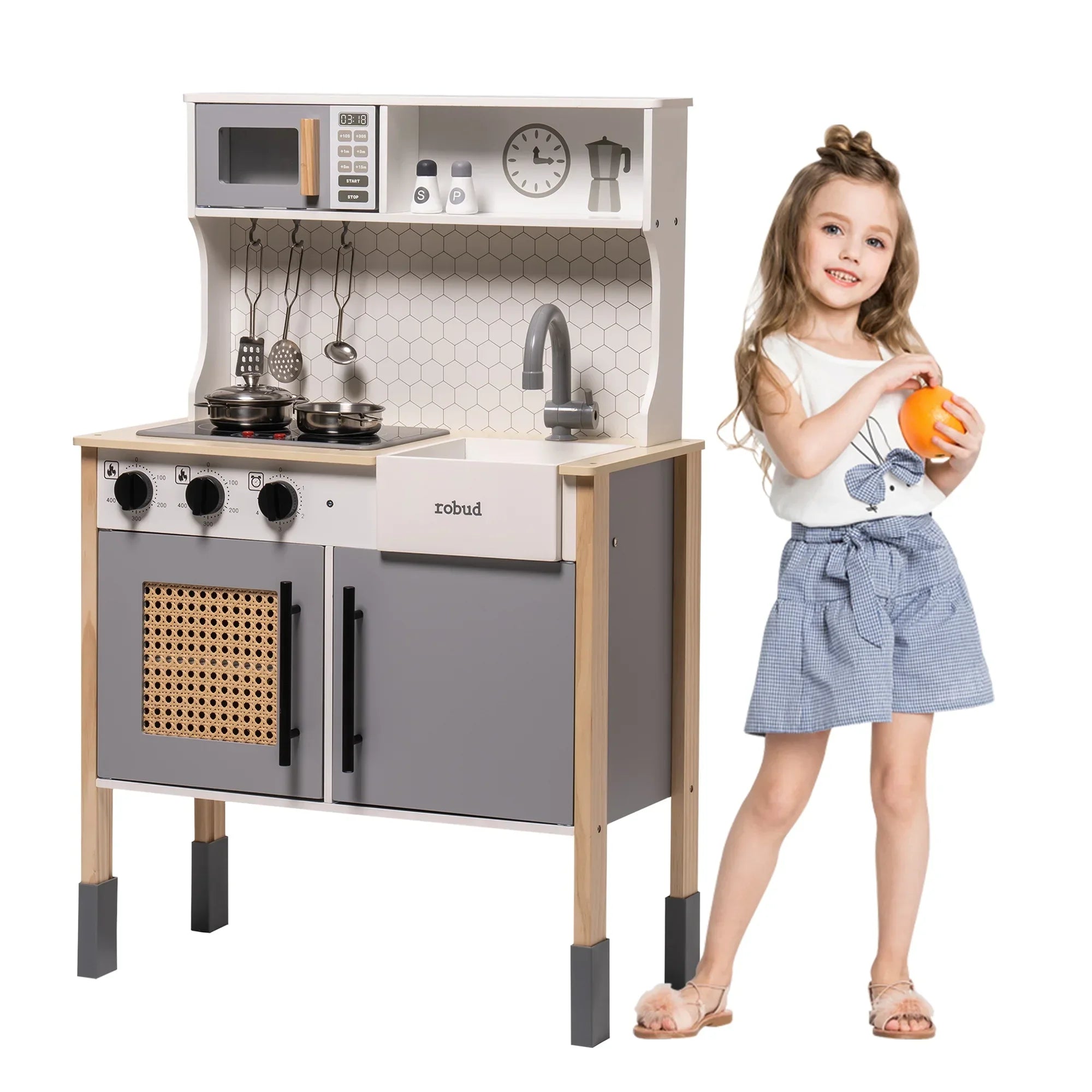 Children's play kitchen set with a girl holding an orange on a white background