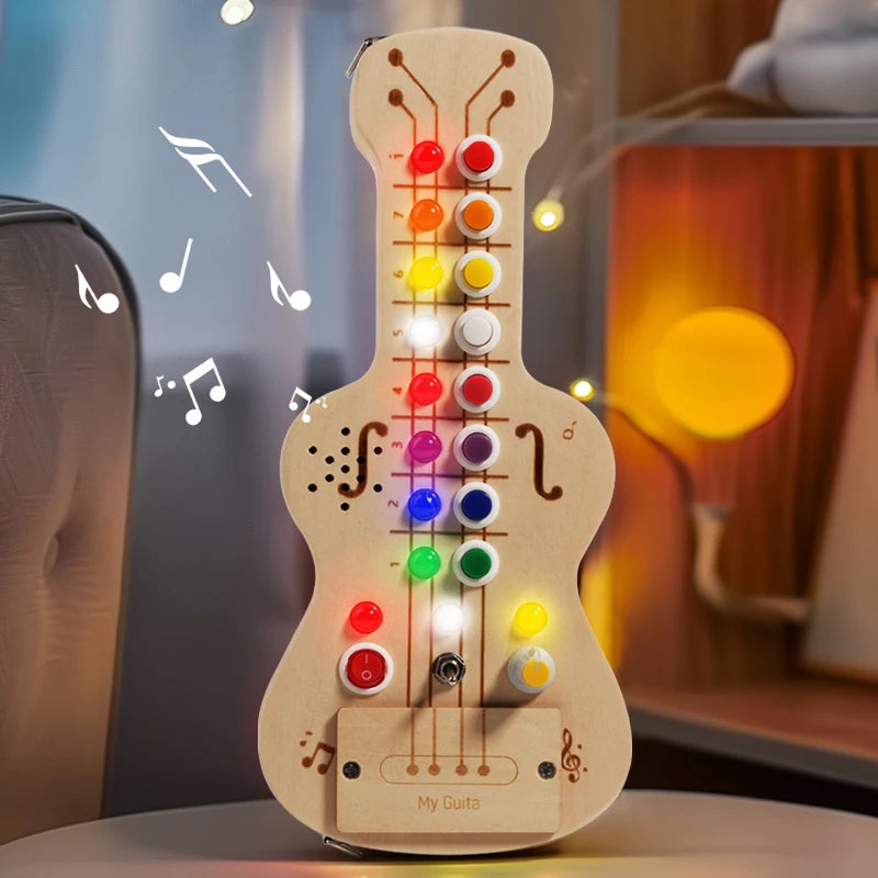 Wooden toy guitar with colorful buttons and lights on a blurred background