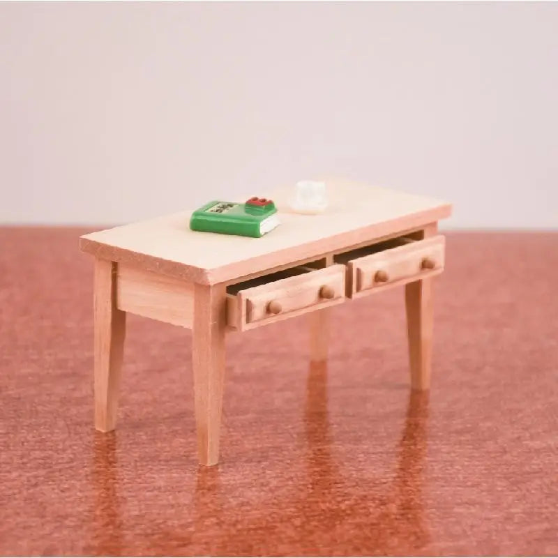 Small wooden table with drawers on a reflective surface