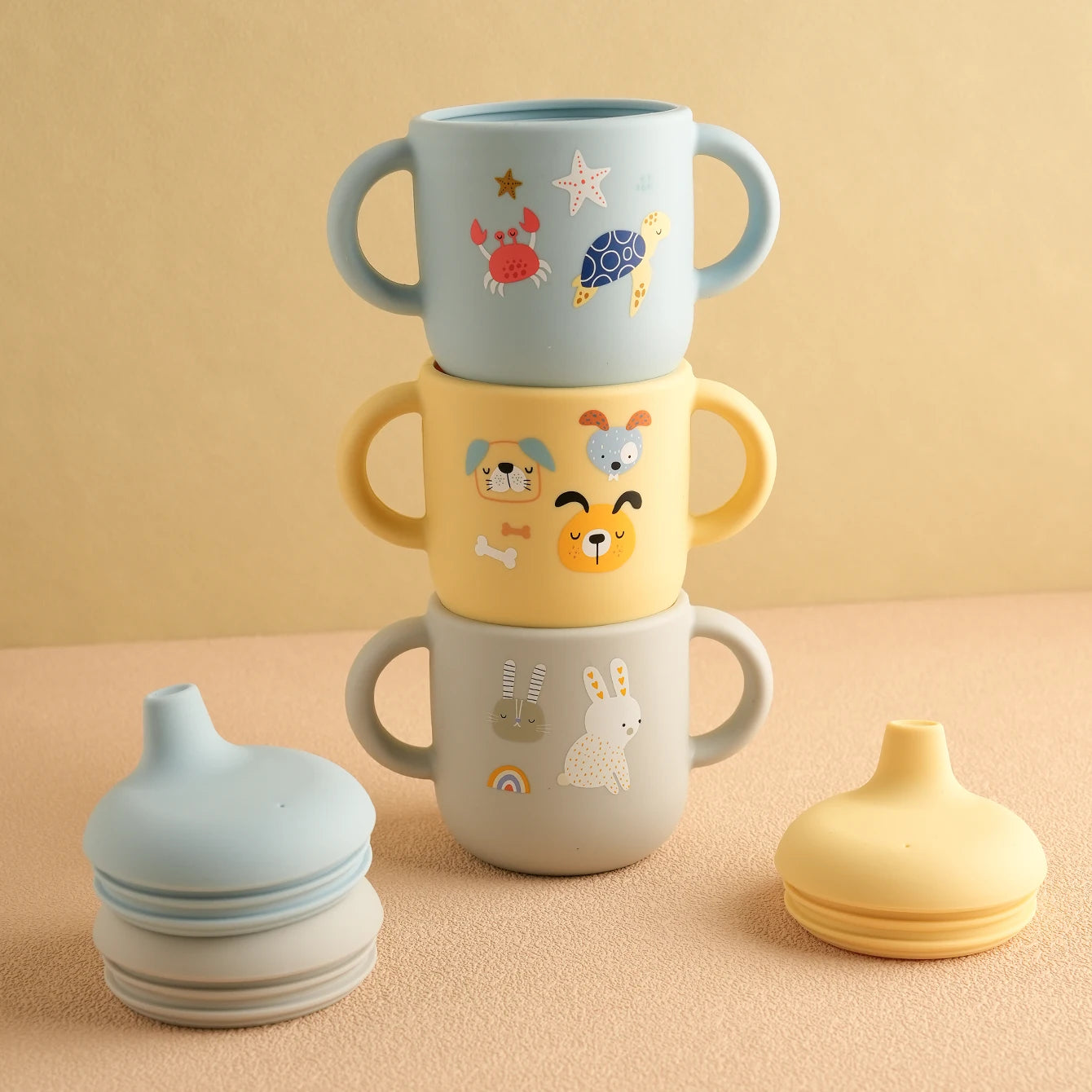 Stacked cartoon sippy cups with their spout lids