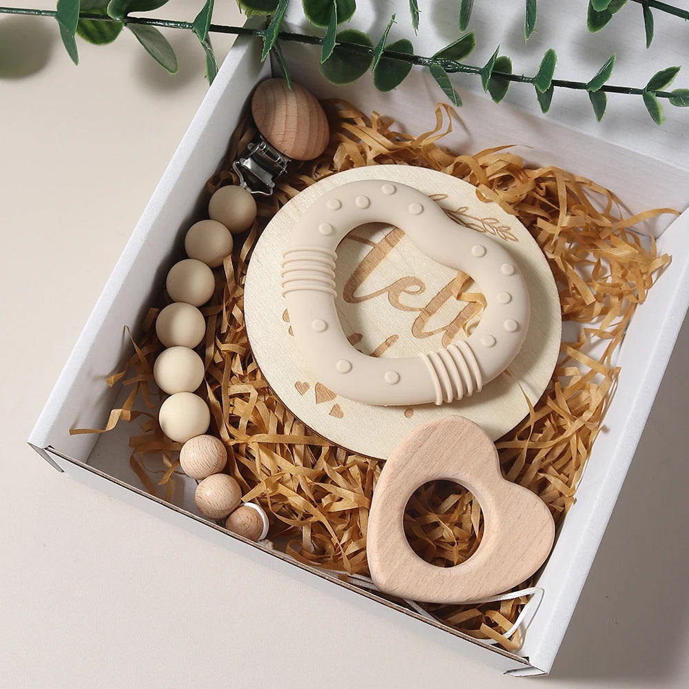 Teething toys in a box with decorative elements on a light background