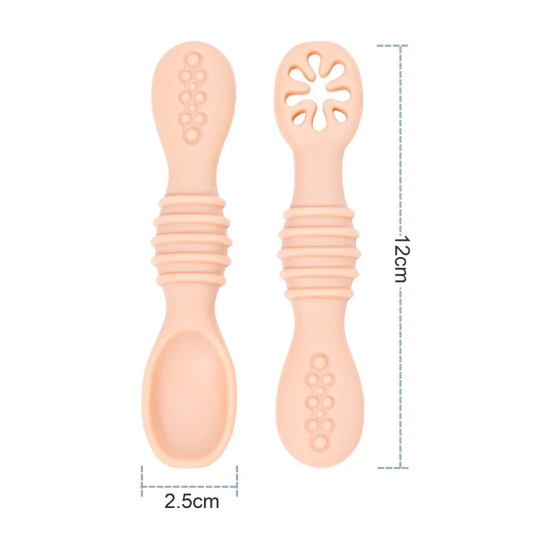 Two peach-colored baby spoons with textured handles and measurements on a white background