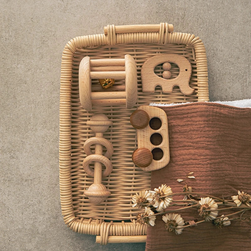 Wooden toys with geometric shapes on a woven tray against a neutral background