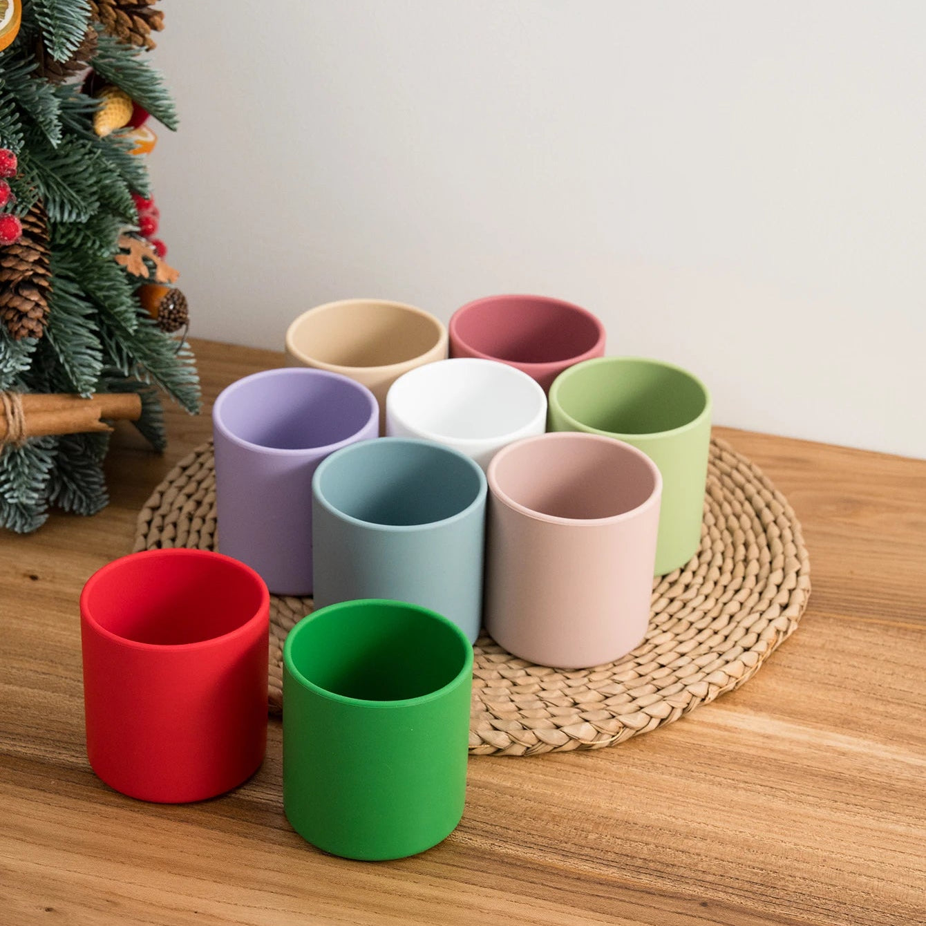 Silicone open training cups in many colors on a table with holiday decor