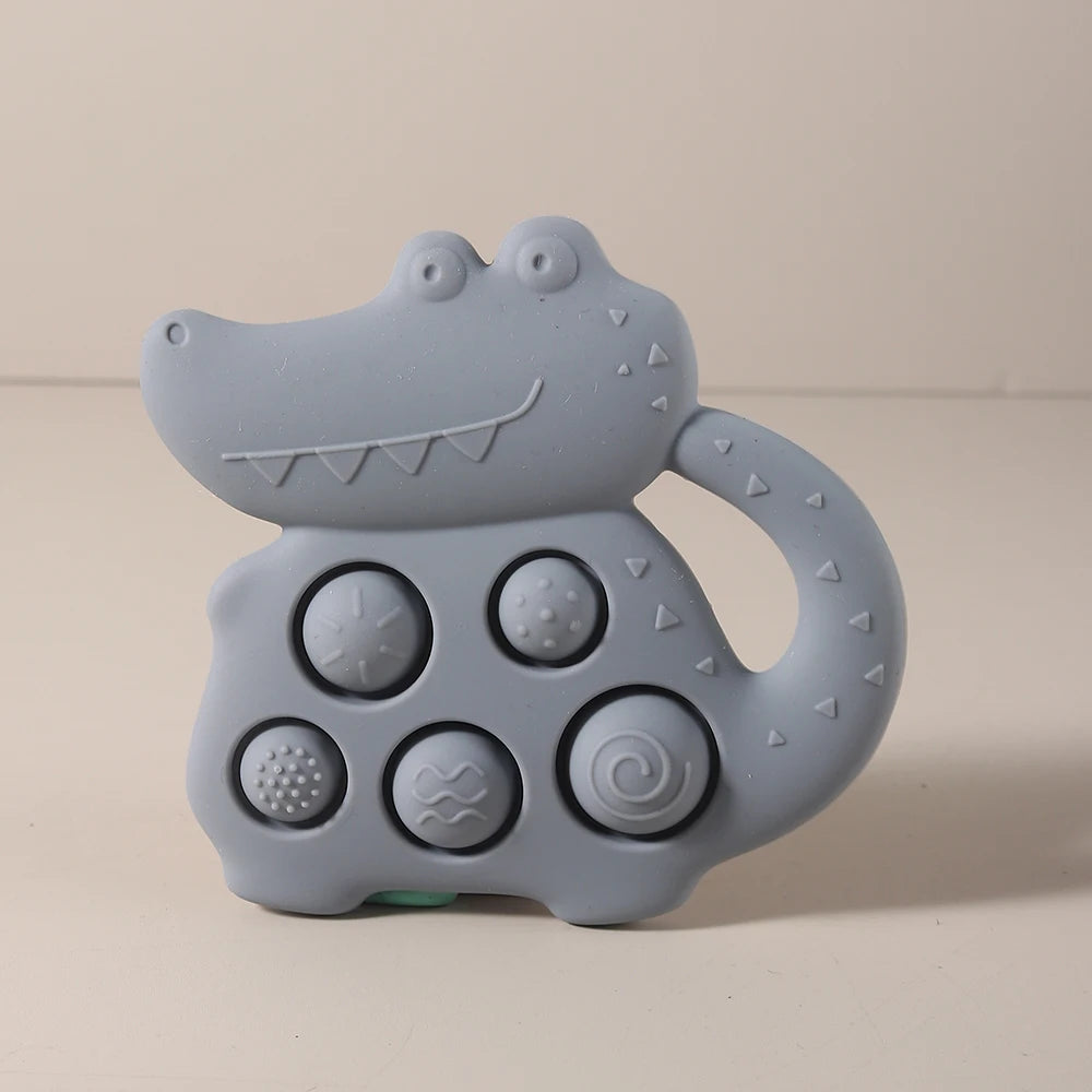 Gray alligator-shaped toy with textured surface on a beige background