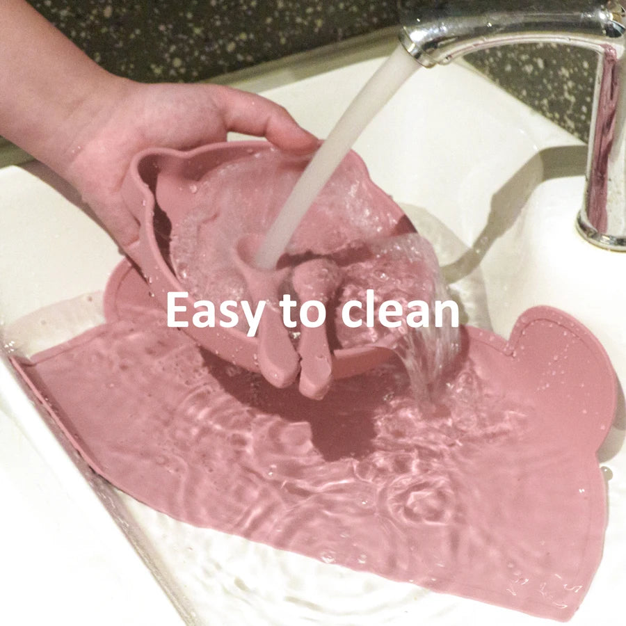 Rinsing the pink bear placemat and plate under a tap