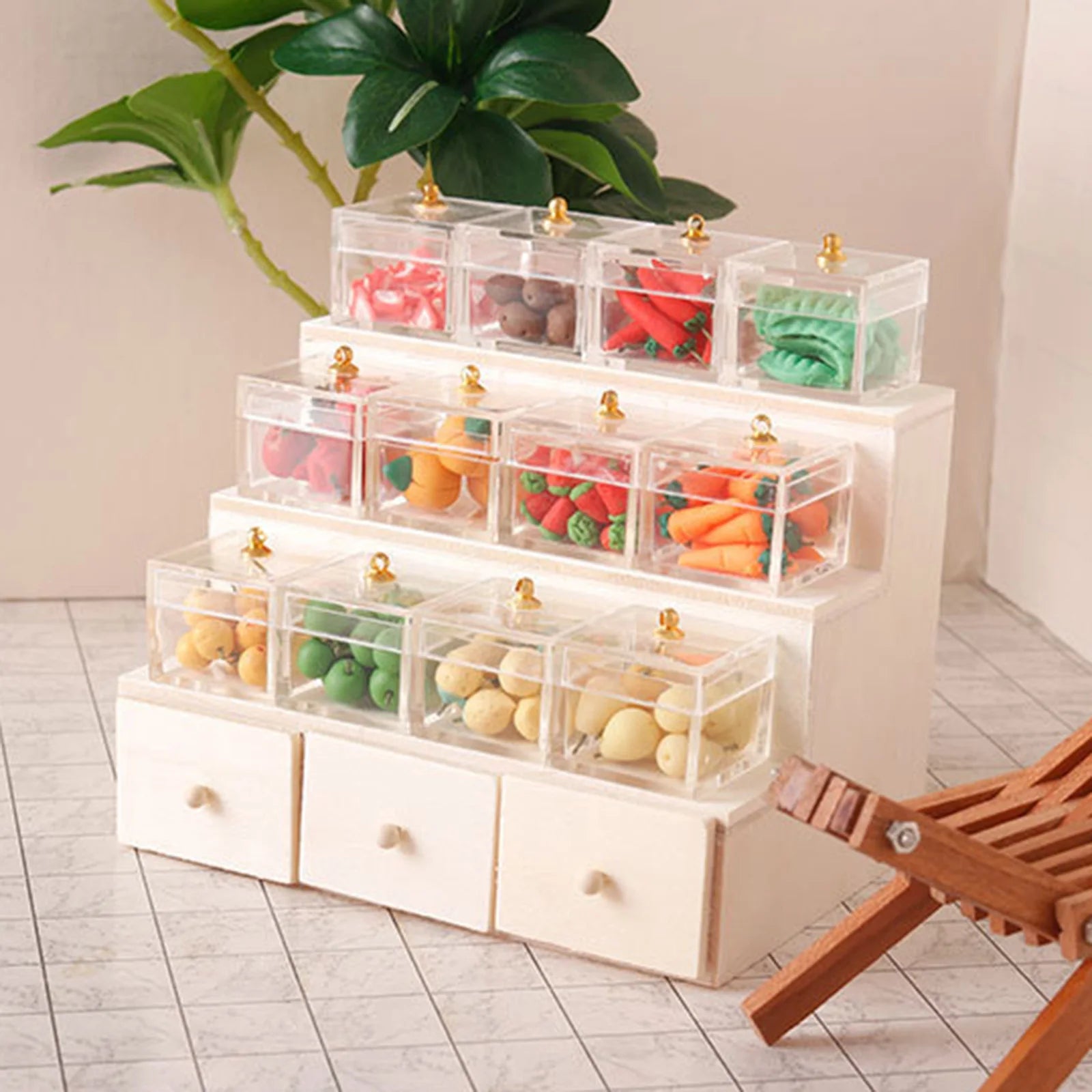 Stack of transparent drawers with food items on a white surface with a plant in the background