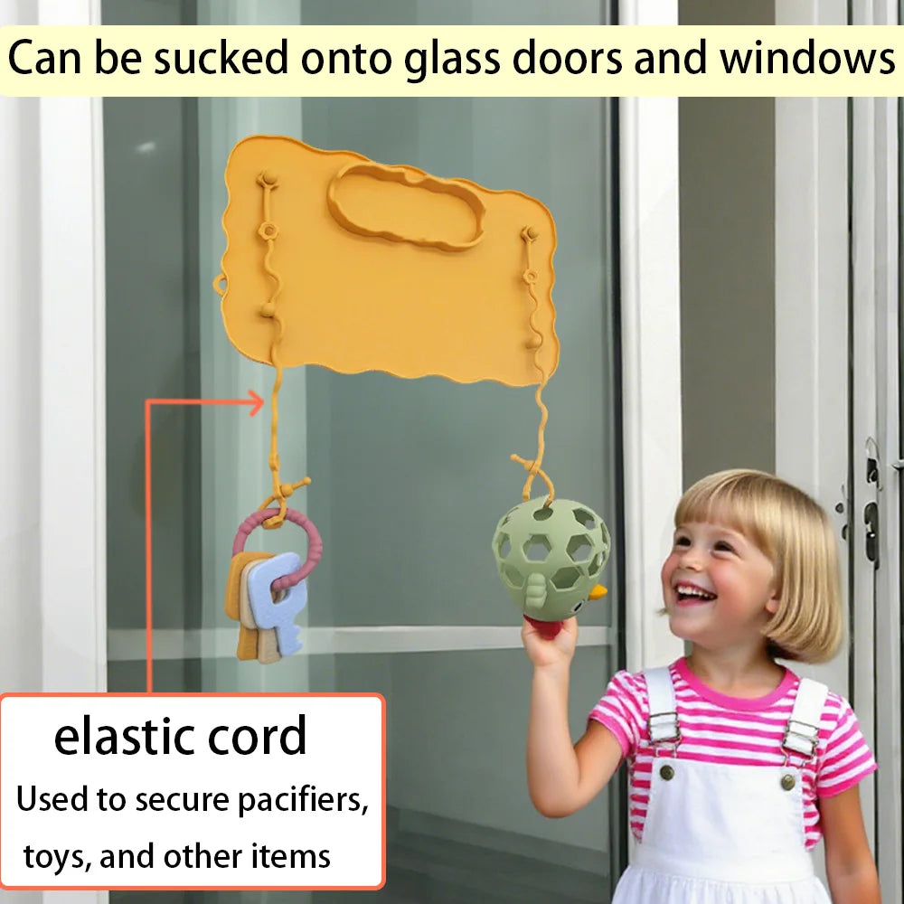 Mustard mat on a glass door with a toy on an elastic strap