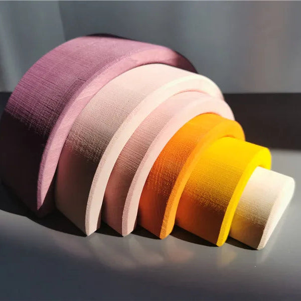 Stack of colorful wooden archs on a gray background