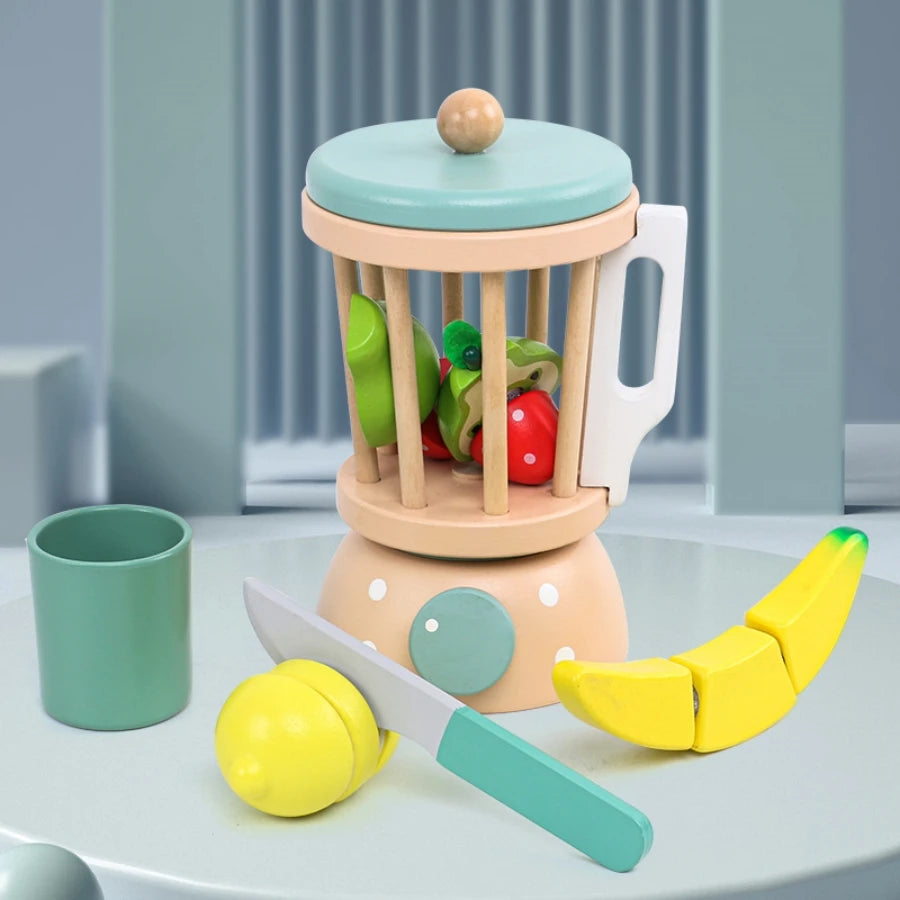 Children's toy kitchen set with a fruit and vegetable grinder, knife, and fruits on a light blue surface.