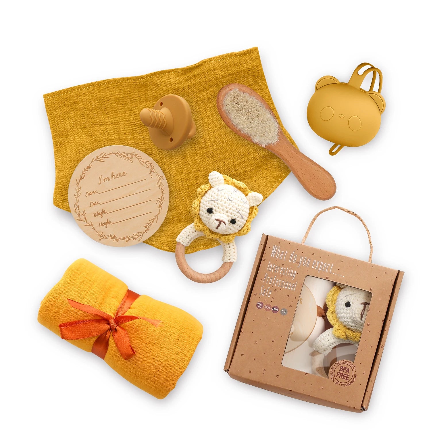 Collection of baby products including a yellow blanket, wooden rattle, and other items on a white background