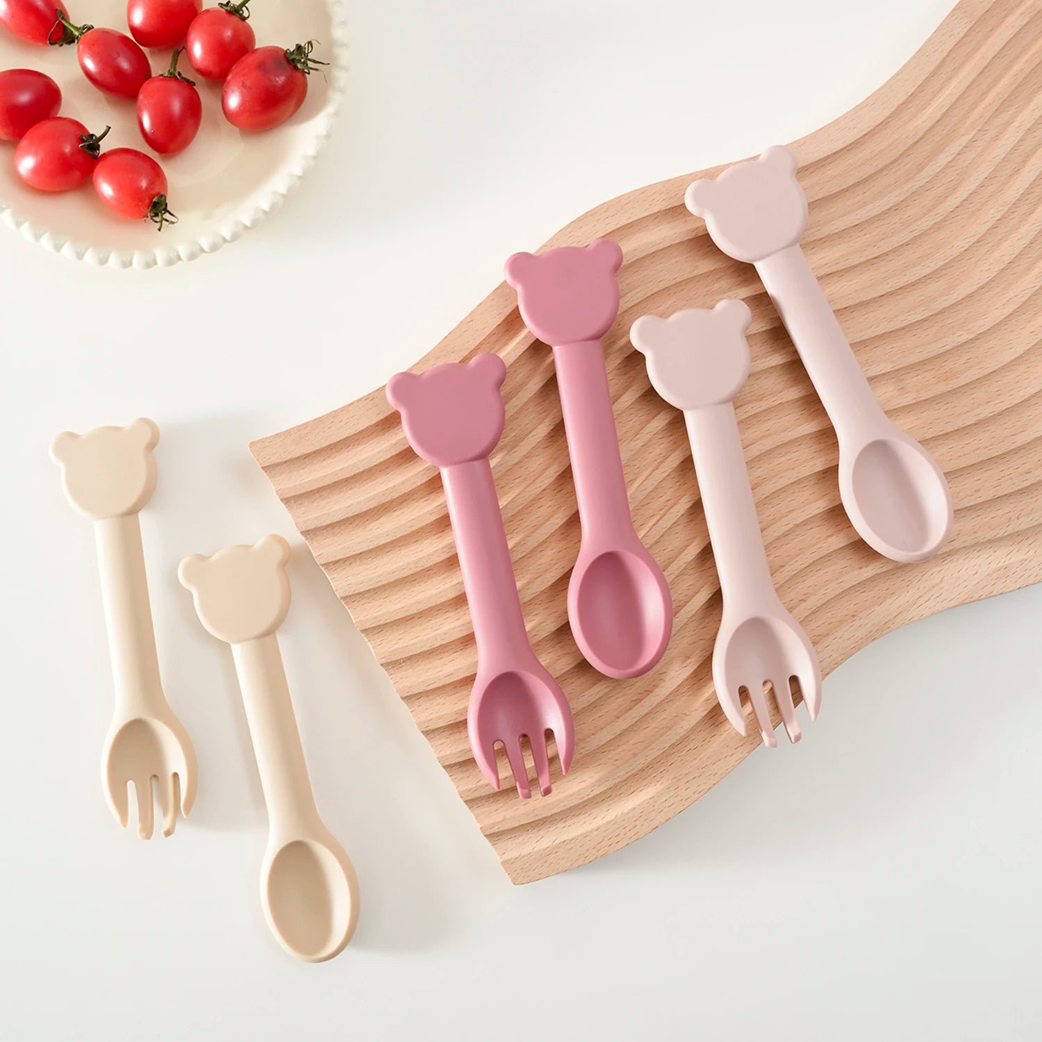 Rose and cream bear spoons and forks beside tomatoes