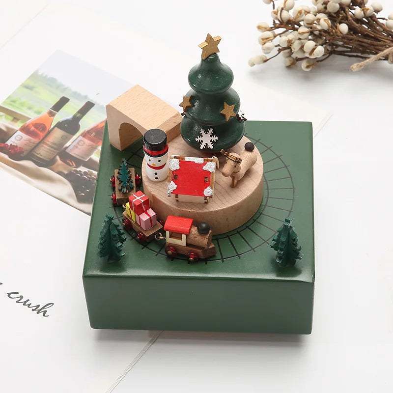 Decorative Christmas-themed music box with miniature figures on a white surface.