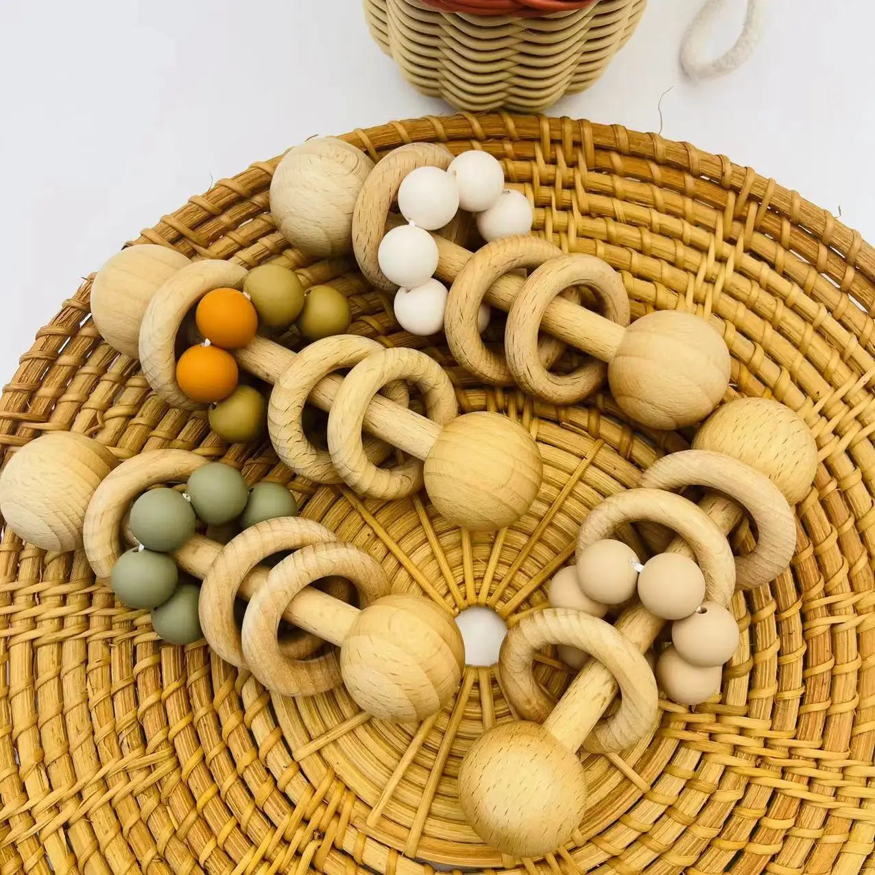 Wooden baby teething rings on a woven mat