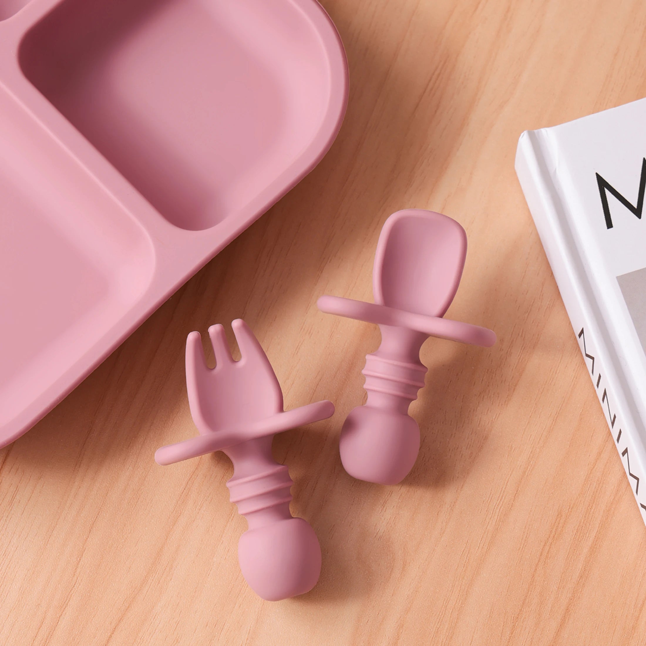 Short-handle silicone spoon and fork beside a divided plate