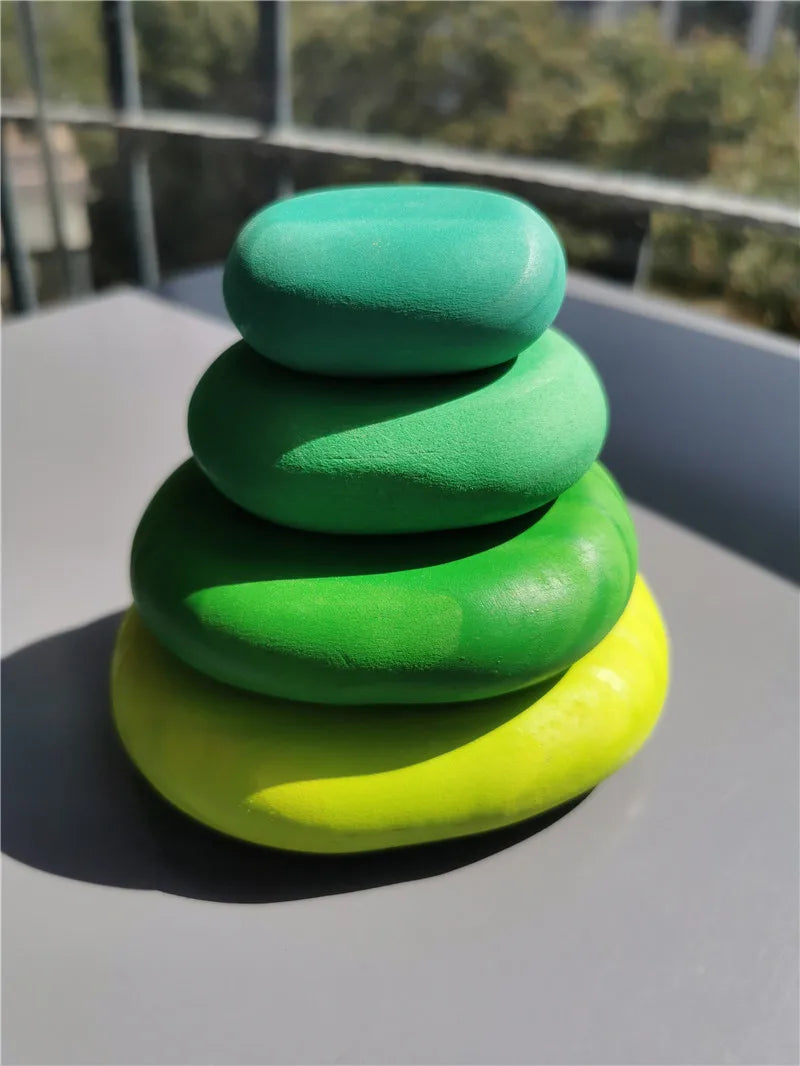 Stack of green and yellow stones on a reflective surface with blurred background