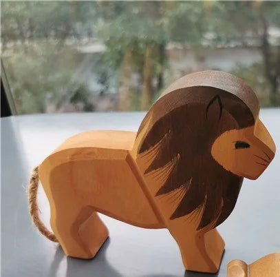 Wooden lion toy on a reflective surface with a blurred natural background