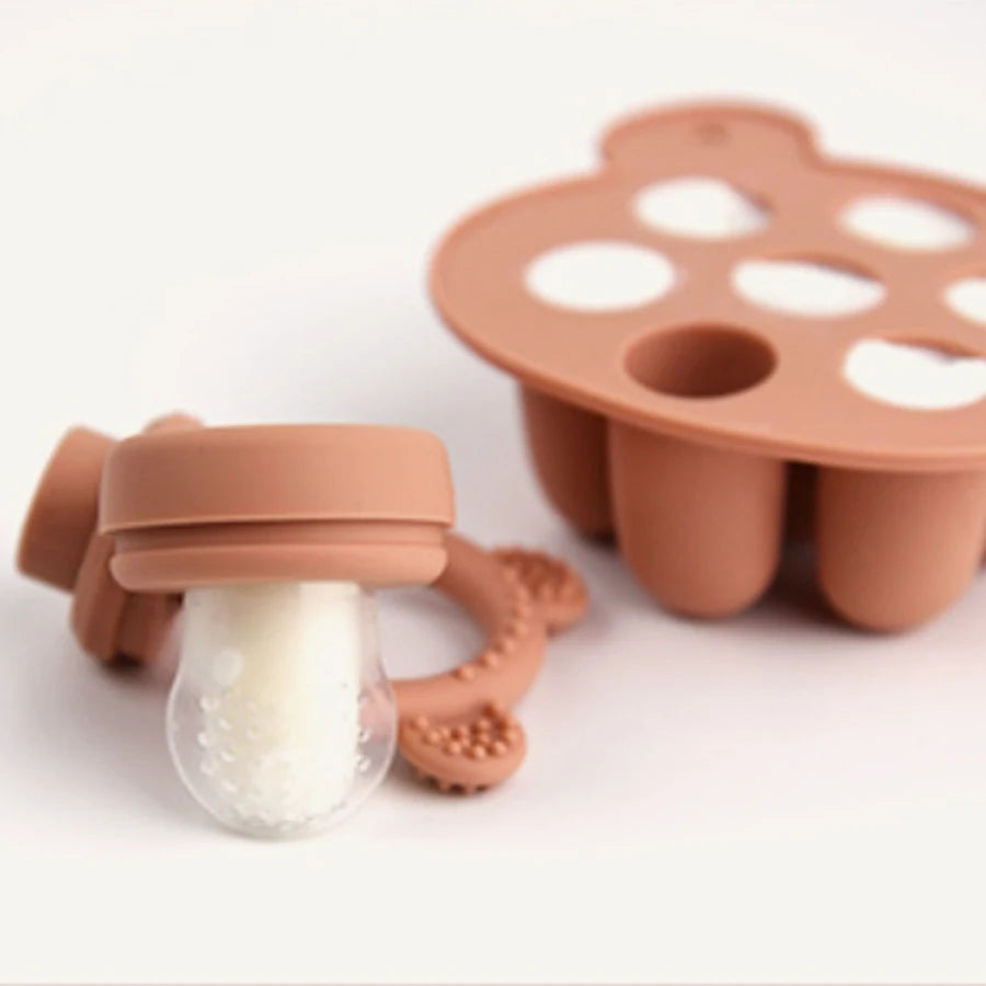 Terracotta popsicle tray beside a fruit feeder with a frozen pop