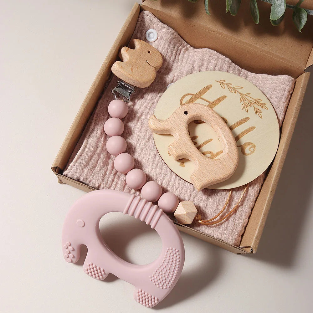 Baby Bib & Teether Gift Set featuring a wooden elephant teether, silicone teether, soft bib, and pacifier chain in a box. Ideal for newborns.